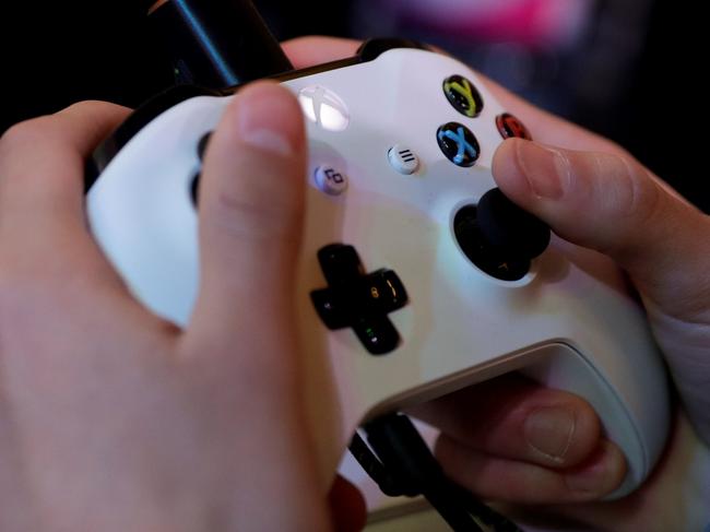 (FILES) In this file photo taken on November 5, 2017 a gamer plays video games with a Xbox console during the 2017 Paris Games Week exhibition at the Porte de Versailles exhibition centre in Paris. Video gaming can be addictive in the same way as cocaine or gambling, the World Health Organization said on June 18, 2018 in a much anticipated update of the International Classification of Diseases (ICD-11). / AFP PHOTO / Thomas SAMSON