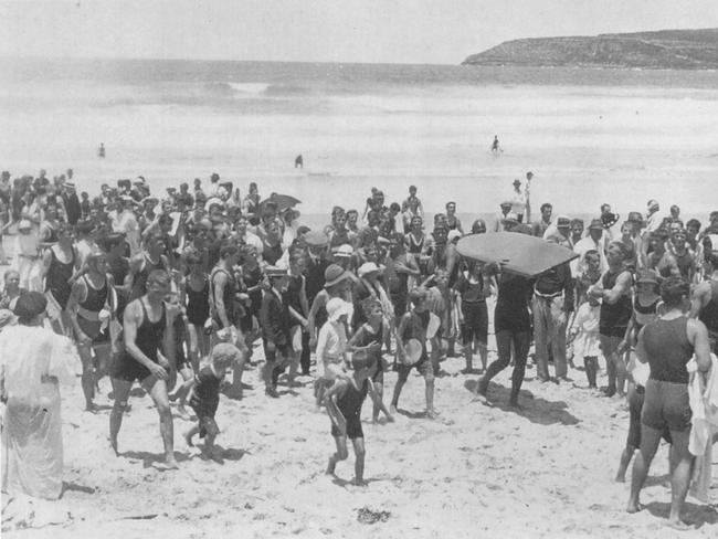 Duke Kahanamoku carrying his board up the beach at Freshwater. Picture: Heather Rose