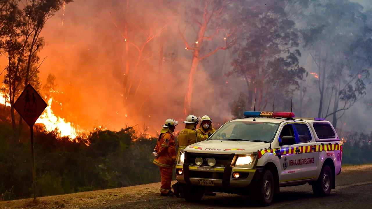 Firefighters regroup as a bushfire burns outside the township of Bargo on Thursday. Picture: Matrix News