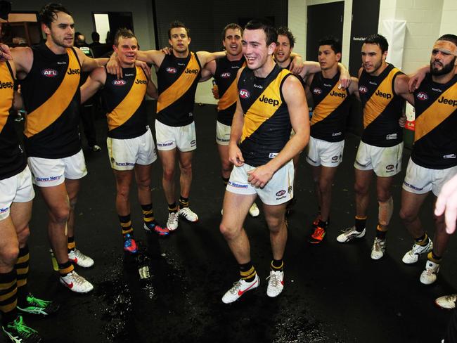 Brett O'Hanlon stands in the middle of the Richmond Tigers circle singing the song.