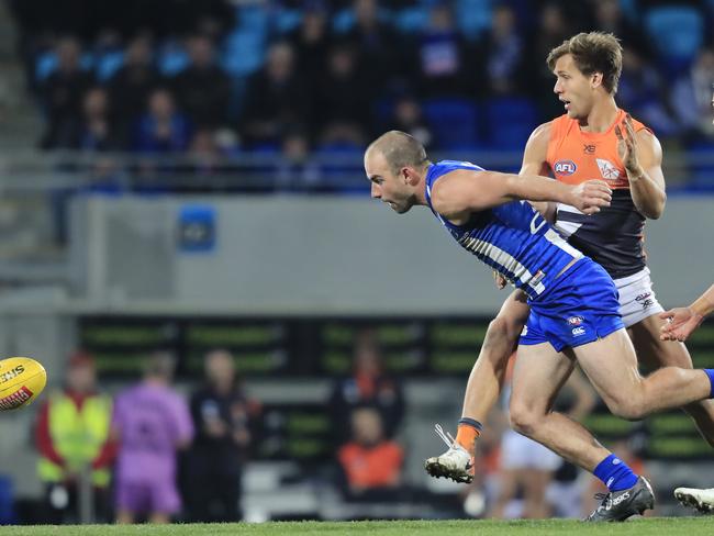 Ben Cunnington of the Kangaroos (left) chases the ball during the Round 13 AFL match between the North Melbourne Kangaroos and the GWS Giants at Blundstone Arena in Hobart, Sunday, June 16, 2019. Picture: AAP Image/ROB BLAKERS