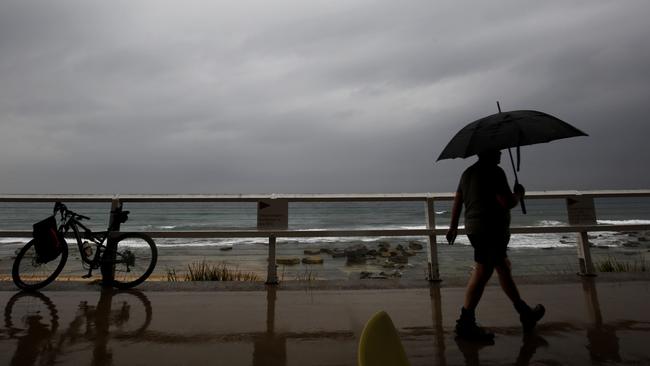 An early morning walker gets out for his exercise at Merewether beach before the worst of the weather hit the Hunter Valley, Wednesday, November 28, 2018. Sydney received more than a month's worth of rain in just two hours - with Observatory Hill recording 84.6mm by 7am. The November average is 83.8mm. (AAP Image/Darren Pateman) NO ARCHIVING