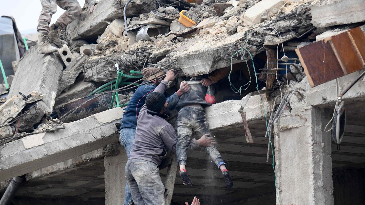 TOPSHOT - Residents retrieve an injured girl from the rubble of a collapsed building following an earthquake in the town of Jandaris, in the countryside of Syria's northwestern city of Afrin in the rebel-held part of Aleppo province, on February 6, 2023. - Hundreds have been reportedly killed in north Syria after a 7.8-magnitude earthquake that originated in Turkey and was felt across neighbouring countries. (Photo by Rami al SAYED / AFP)