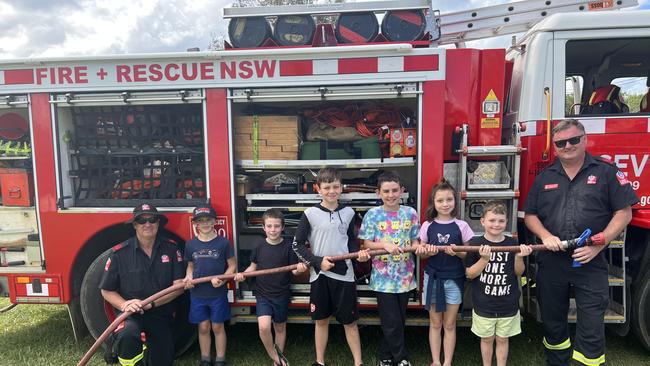 Firefighter Kenny Harrison, Ashton Smith, Riley Nash, Jarrah Robinson, Ryder Davies, McKenzie Robinson, Dexter Robinson and firefighter Dean Wilson in front of the Fire and Rescue NSW truck at the 120th Murwillumbah Show. Picture: David Bonaddio