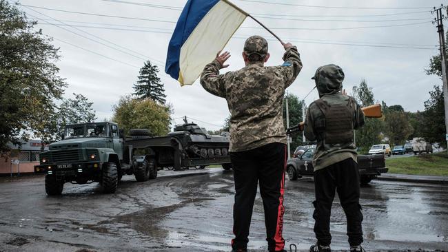 Denys, 13, and Sasha, 10, cheer to passing vehicles from their mimicked checkpoint at the curve of a road in Chuhuiv, Kharkiv region. Kyiv said its forces had recaptured a village in the eastern Donetsk region and territory around another war-scarred town there, as Moscow-proxies held votes on annexation by Russia. Picture: AFP