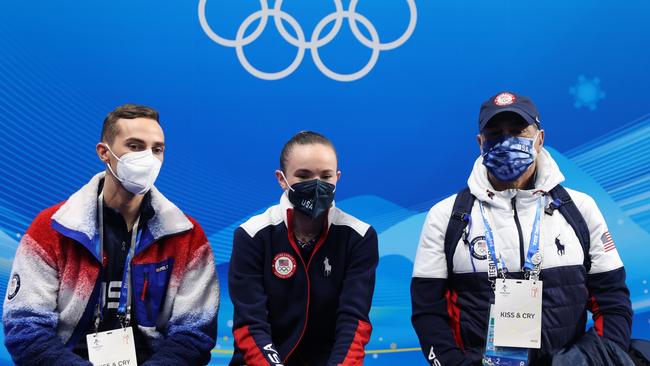 Mariah Bell waits for her score with coaches Adam Rippon (L) and Rafael Arutyunyan (R).