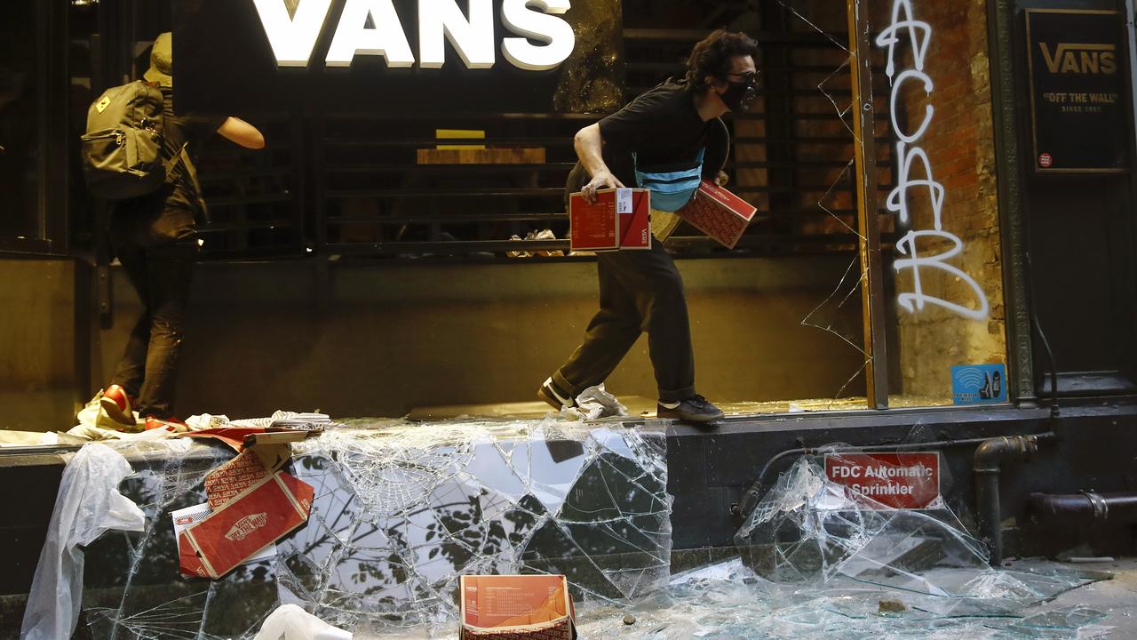 Looters leave a shoe store in Philadelphia. Picture: Matt Rourke/AP