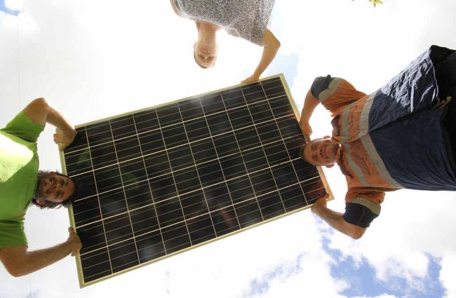 Kon Flaherty with Sharron and William Pratt holding one of the 192,000 solar panels that could soon be installed at Kelsey Creek outside Proserpine. . Picture: Peter Carruthers