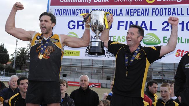 Father-son duo Frankston YCW captain Anthony Barry and coach Tony Barry lift the premiership cup in 2010.