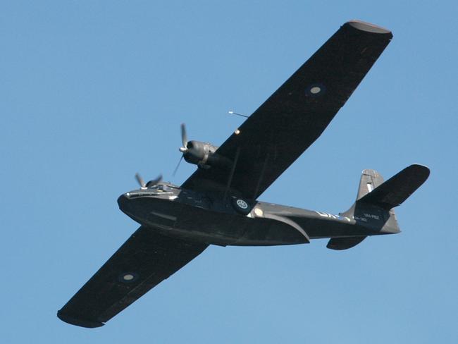 An historic World War II amphibious long range patrol aircraft, a Catalina in wartime RAAF "Black Cat" colour scheme, flies past.  Deep caption  Salute to Veterans was a national public event in Canberra on 13-15 August 2005 to thank Australia’s World War II veterans for their contribution, achievement and sacrifice on the 60th anniversary of Victory in the Pacific. The event was organised by the Department of Veterans Affairs as the centerpiece of VP Day commemorations in State capitals and regional centres around Australia.  The Department of Defence extensively supported and contributed to the Salute to Veterans event in Canberra, with the National Capital Authority, Temora Aviation Museum, Canberra International Airport, the Historical Aviation Restoration Society, Qantas, Old Parliament House, and the National Archives of Australia.