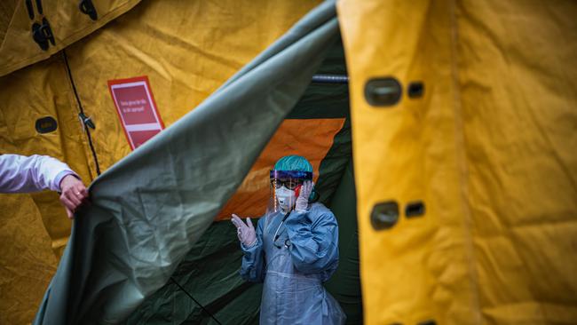 A medical staffer at Sophiahemmet hospital talks on a cell phone inside a tent for testing and receiving potential coronavirus COVID-19 patients Stockholm.