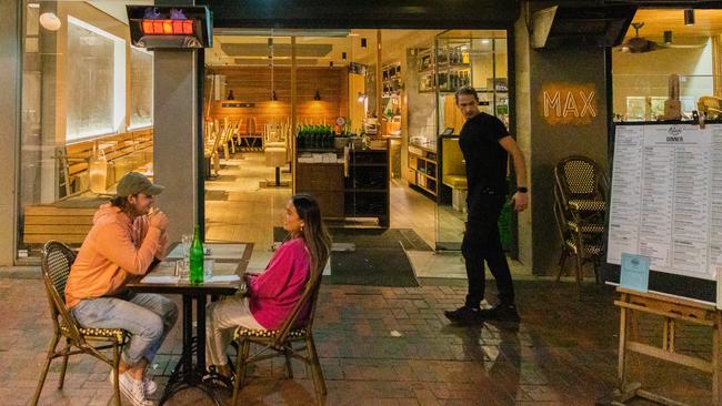 A few customers have dinner surrounded by empty tables at a restaurant over the weekend in Melbourne. Picture: Getty Images