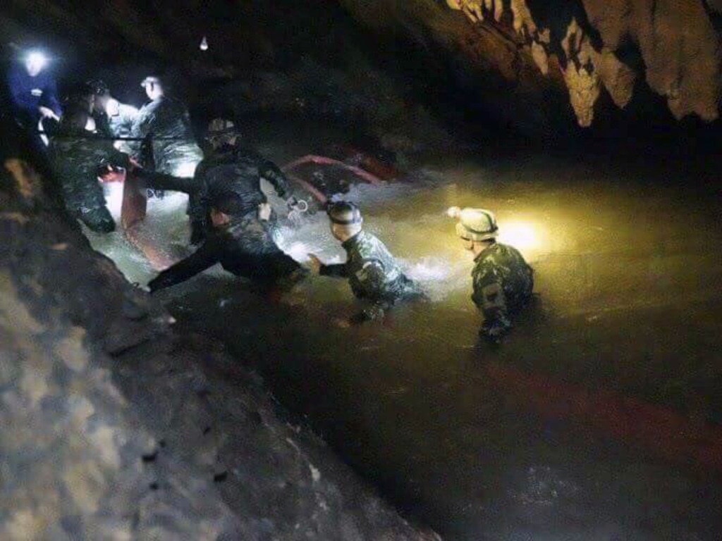 Thai rescue teams walk inside the cave complex where 12 boys and their soccer coach were trapped in northern Thailand. Picture: AP