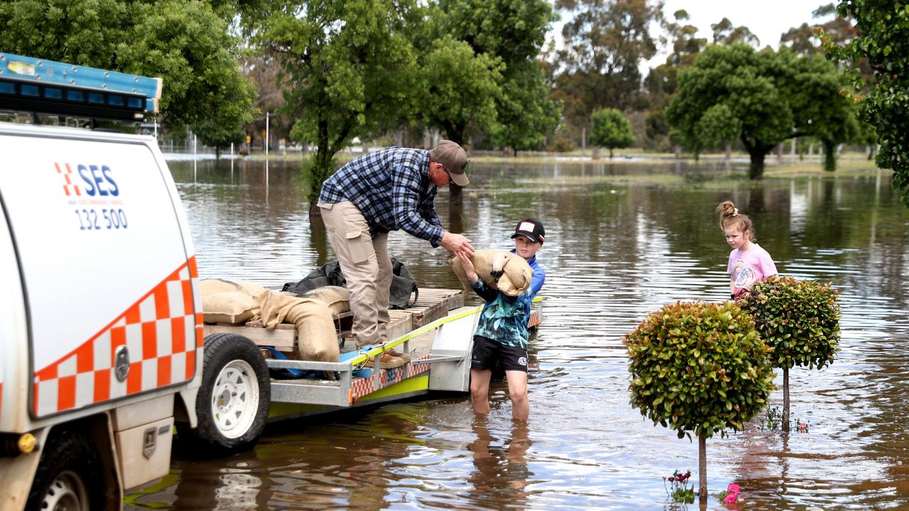 People carry sandbags through flood waters in Forbes, Australia in November. Picture: Brendon Thorne / Getty Images / POOL / NCA NewsWire