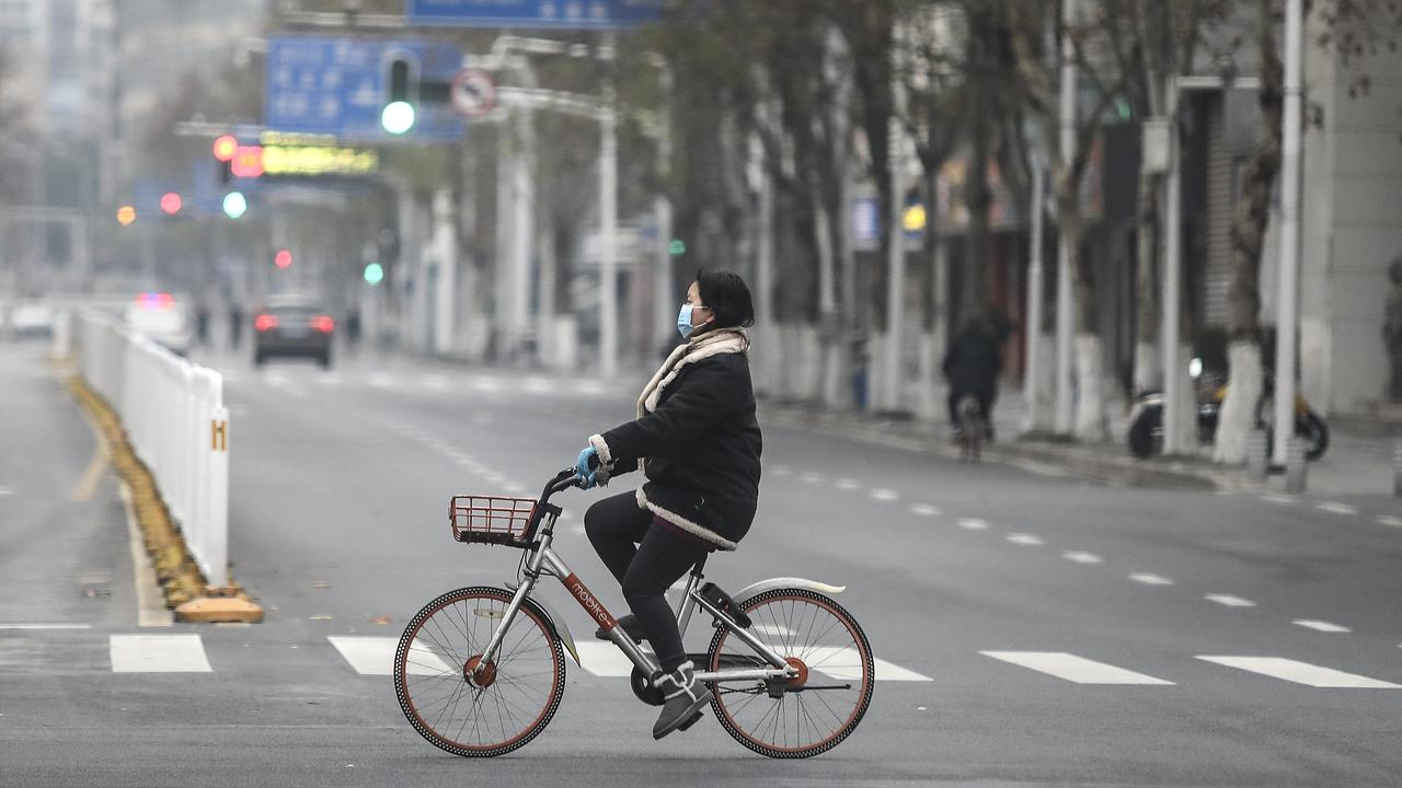 A woman wearing a protective mask rides a motorised bike in Wuhan. Picture: Getty Images