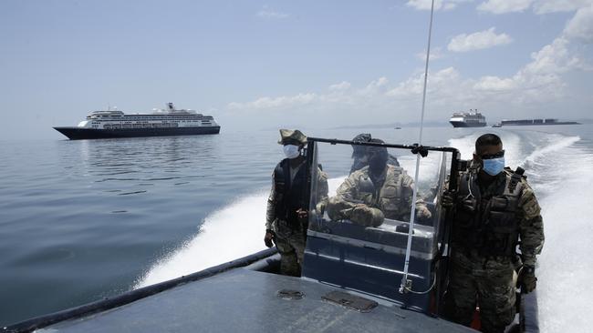 Panamanian navy Police navigate near the anchored Zaandam cruise ship. Health authorities are expected to board the ship to test passengers and decide whether it can cross the Panama Canal.