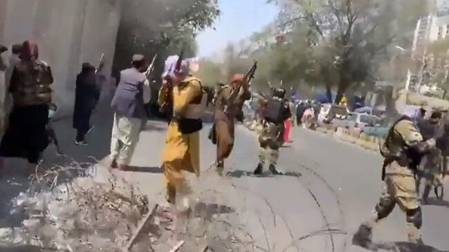 Taliban fighters opening fire (above) on a street protest against their regime.