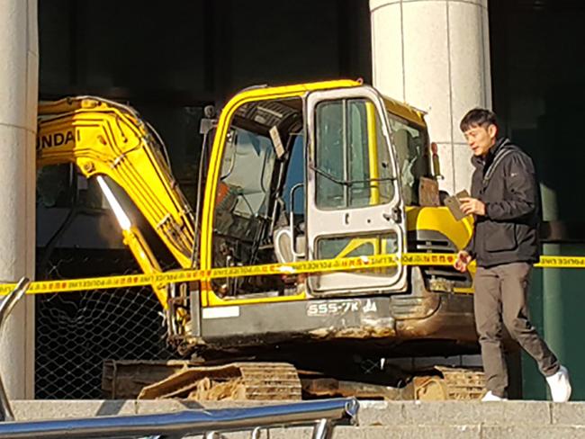 Cameramen surround an excavator after its driver attempted to ram the Seoul Central District Prosecutor's Office in Seoul where Choi Soon-Sil, the woman at the centre of South Korea's current political crisis, is being held on November 1, 2016. Choi, the woman at the centre of the snowballing political scandal engulfing President Park Geun-Hye, is a 