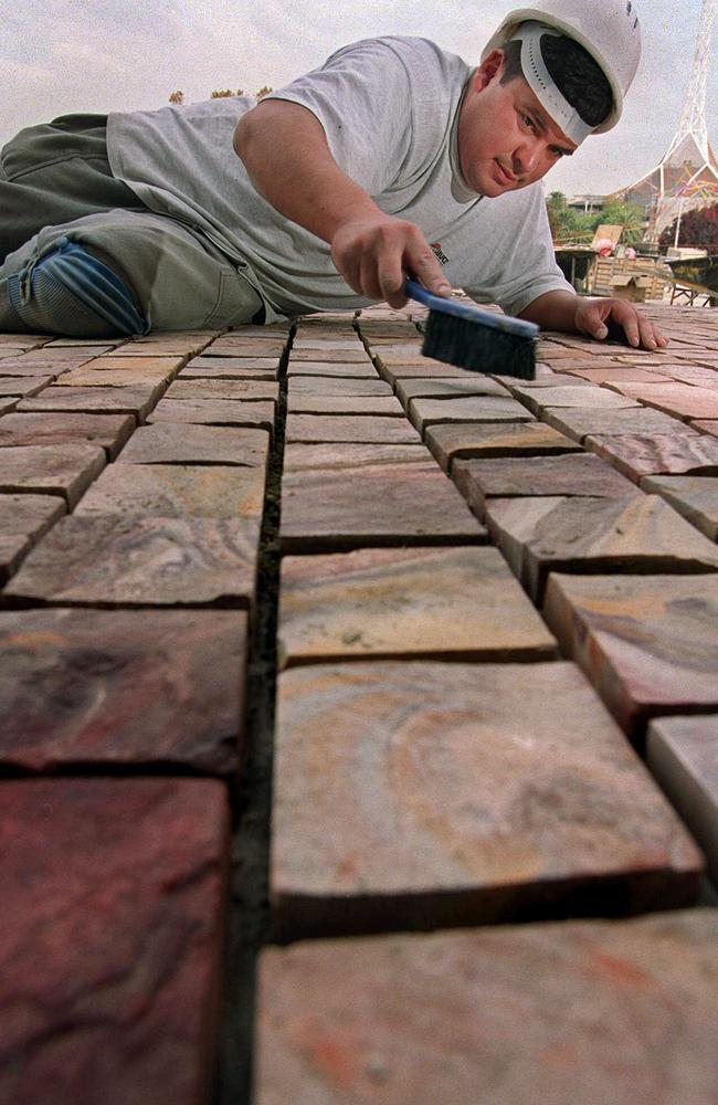 Luis Trejo brushes cobbles for the plaza at Federation Square in 2000. Picture: HWT Library