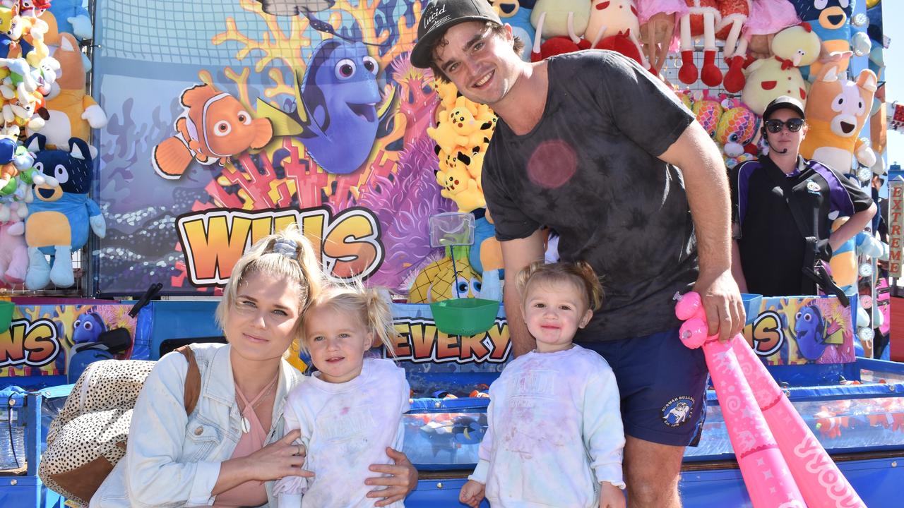 Carly and Coady Bell of Bowen trying their luck in sideshow alley with three-year-old twins Alexis and Ayla. Picture: Kirra Grimes