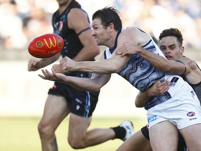 GEELONG, AUSTRALIA – MAY 21: Patrick Dangerfield of the Cats handballs while being tackled by Karl Amon of the Power during the round 10 AFL match between the Geelong Cats and the Port Adelaide Power at GMHBA Stadium on May 21, 2022 in Geelong, Australia. (Photo by Daniel Pockett/AFL Photos/via Getty Images )