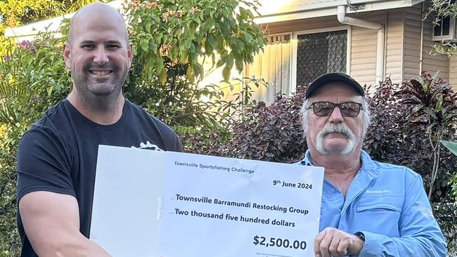 Townsville Barramundi Restocking Group president Rhyce Bullimore accept a generous donation by Townsville Saltwater Sportman's Club president Jeff Hopkins – right.