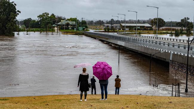 Locals watch on as the water rises to the Windsor Bridge. Picture: NCA NewsWire / Flavio Brancaleone