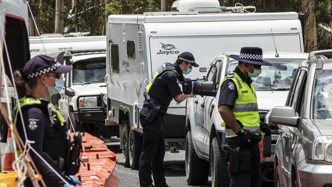 Police officers patrol and check for entry permits to Victoria. Picture: Getty