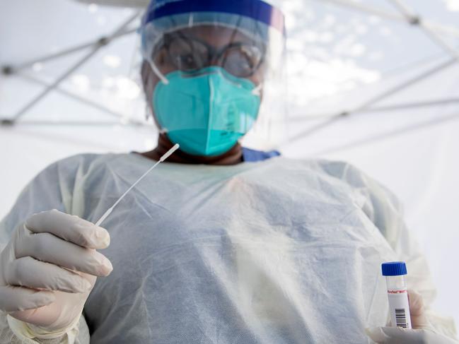 TOPSHOT - A health worker takes a nasal swab sample at a COVID-19 testing site at St. John's Well Child and Family Center, amid the novel coronavirus pandemic, July 24, 2020, in Los Angeles, California. - The coronavirus pandemic hit grim new milestones July 23, with cases topping four million in the United States and three million in Europe as fresh spikes from Belgium to Tokyo to Melbourne forced new restrictions on citizens. (Photo by VALERIE MACON / AFP)