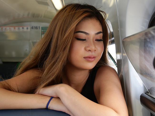 Anna Tham from Campbelltown trying to stay cool on her train to Cabramatta. Picture: Jonathan Ng