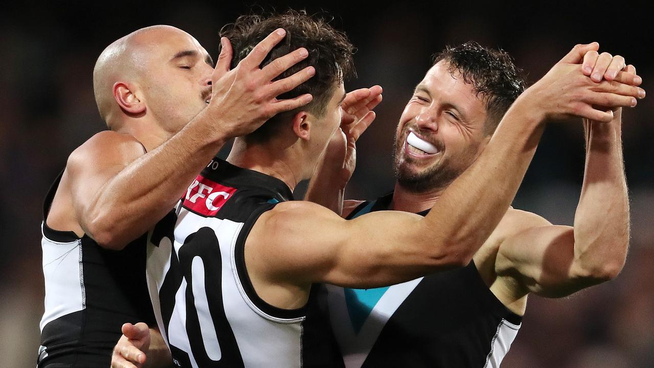 Connor Rozee celebrates a goal with teammates Sam Powell-Pepper and Travis Boak at the Adelaide Oval. Picture: Sarah Reed/AFL Photos via Getty Images