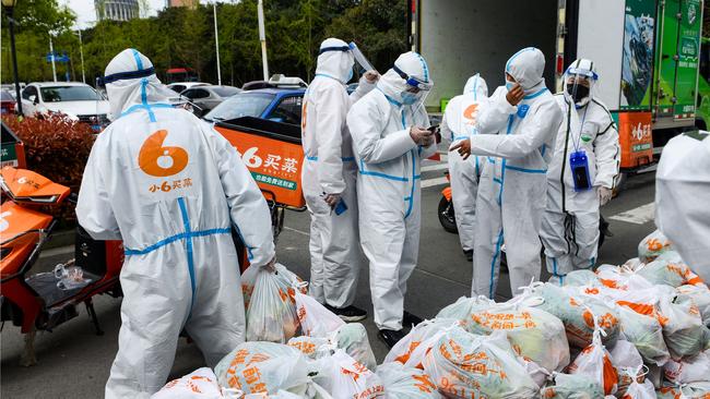 Delivery men wearing personal protective equipment prepare to deliver food bought online for residents who were restricted due to a recent Covid-19 coronavirus outbreak in China. Picture: AFP