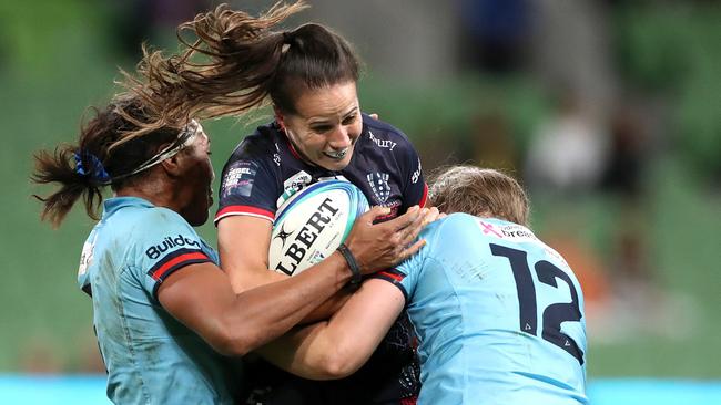 Meretiana Robinson of the Rebels is tackled by Sera Naiqama of the Waratahs and Ella Ryan of the Waratahs during a Super W match this season.