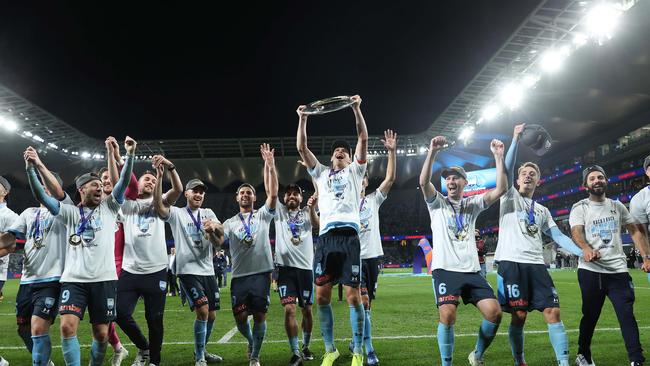 Alex Wilkinson (centre) and his Sydney FC teammates celebrate winning the A-League grand final. Picture: Brett Costello