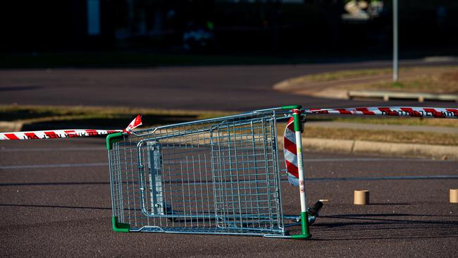 A tipped over shopping trolley forms part of the boundary to the crime scene at the Karama shopping centre. Picture: Che Chorley