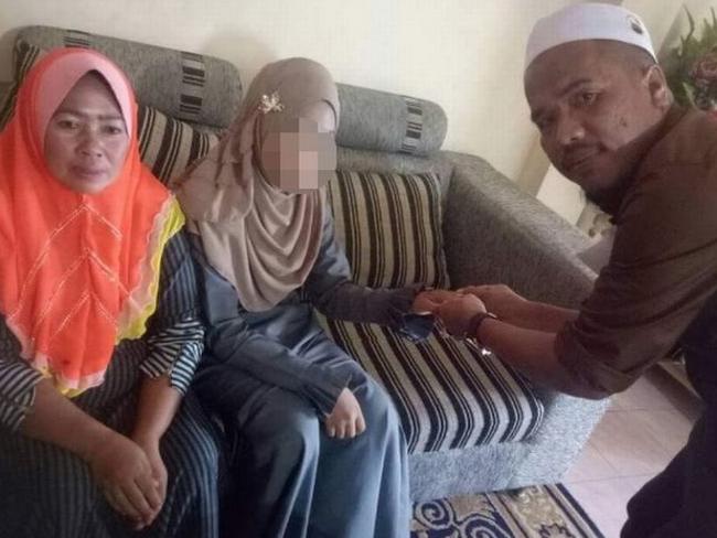 Malaysian national Che Abdul Karim, 41, poses with his latest wife Ayu, 11, (centre) and her mother (left) at a home in the Thai border village of Sugai Golok. Picture: Twitter