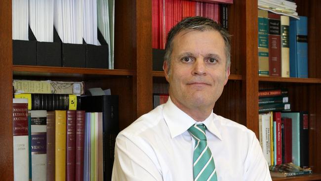 SA State Coroner Mark Johns, pictured in his office, is holding an inquest into the deaths of Michael John Russell and Leslie Robert Graham.