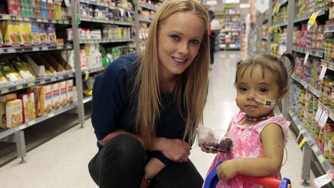 Montana doesn’t let her condition stop her from helping her mum Monique Bibby do the grocery shopping. Picture: Richard Serong