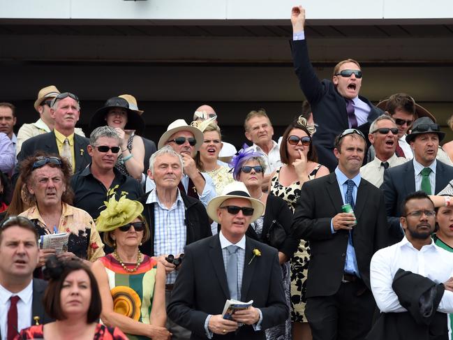 A punter passionately calls his horse home as it closes in on the winning post in the last race at Flemington. Picture: Jason Sammon