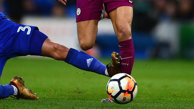 Leroy Sane of Manchester City is tackled by Joe Bennett of Cardiff City