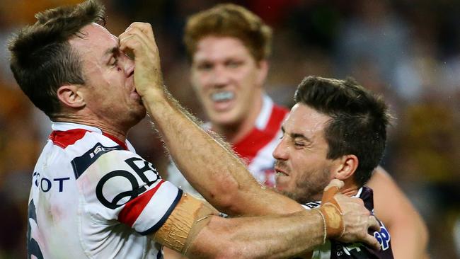 Bronce Ben Hunt confronts the tackle of Roosters five-eighth James Maloney. Picture: Darren England