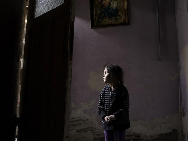 Four-year-old Ana-Maria Tudor stands in her doorway in Bucharest as her family faces eviction from their one-room home, after her father’s gall bladder surgery left him unable to work. Picture: Renee Byer