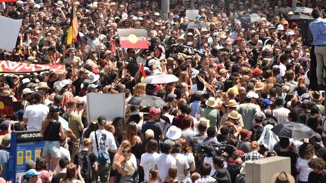 People take part in an "Invasion Day" rally on Australia Day in Melbourne on January 26, 2018. Thousands of supporters joined rallies across Australia calling for equal rights for indigenous people and for an end to the celebration of Australia Day on January 26, which marks the official declaration of British sovereignty on the land that eventually became Australia. / AFP PHOTO / Peter PARKS