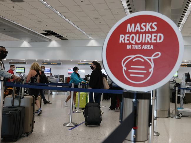 MIAMI, FLORIDA - FEBRUARY 01: A sign reading, 'masks required in this area,' is seen as travelers prepare to check-in for their Delta airlines flight at the Miami International Airport on February 01, 2021 in Miami, Florida. An executive order signed by U.S. President Joe Biden last week mandates mask-wearing on federal property and on public transportation as part of his plan to combat the coronavirus (COVID-19) pandemic.   Joe Raedle/Getty Images/AFP == FOR NEWSPAPERS, INTERNET, TELCOS & TELEVISION USE ONLY ==