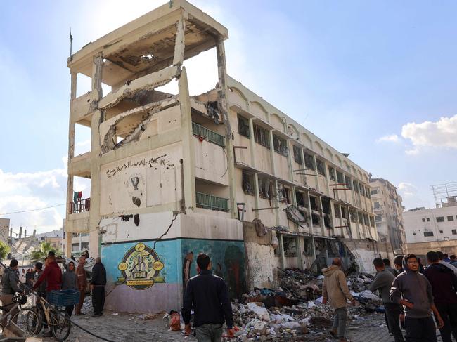 People inspect the damage following an Israeli strike on the UNWRA Al-Majda Wasila Governmental School housing displaced Palestinians, on al-Jalaa Street in Gaza City on December 14. Pictute: Omar Al-Qattaa/AFP