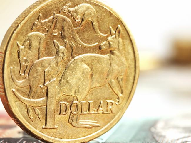 Generic photo of an Australian dollar coin .. Aussie one dollar coins, on a twenty dollar note.