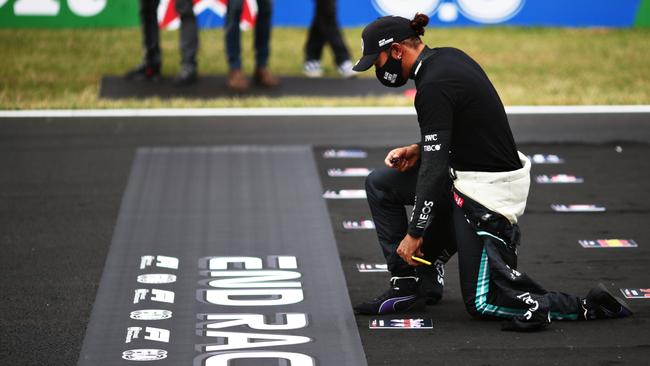 Lewis Hamilton of Great Britain and Mercedes GP takes a knee