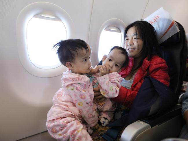 Mum Bhumchu holds Nima and Dawa during the flight from Bhutan to Bangkok. Picture: Alex Coppel