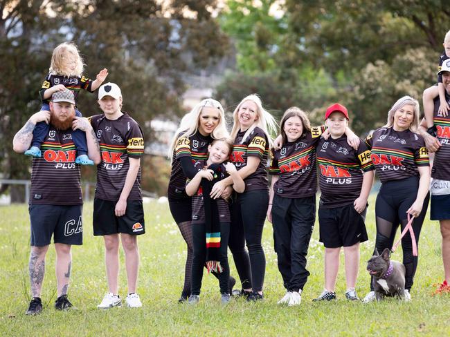 30-09-21 -  Eleven Penrith fans in one household in Hebersham - L-R Jake green, (kayne green - on Shoulders) DJ Green, Jasmin Srsa, Pyper Green, Phalen Cassan,  Trinity Petersen, Curtis Green, Bobbie Green, Daniel Green,  (Joel Petersen - on shoulders) and the dog is diamond green-PIC: Ryan Osland