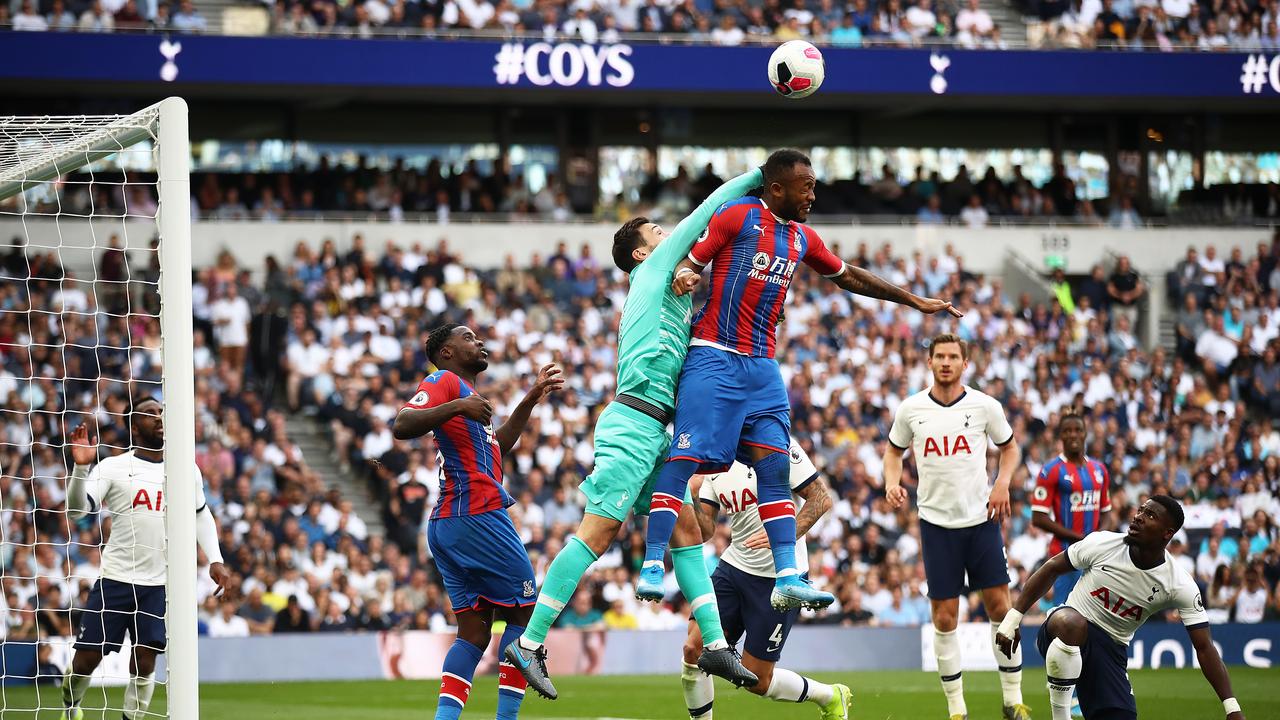 Hugo Lloris of Spurs punches the ball clear ahead of Jordan Ayew of Crystal Palace. (Photo by Julian Finney/Getty Images)